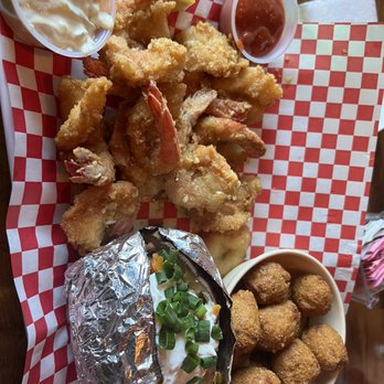 Pier 77 - Butter Garlic Parmesan shrimp, side of hush puppies and loaded baked potato - Seafood Near Me - Fulton, Texas