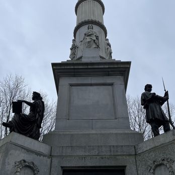 Boston Common - A monument featuring a tall column with statues at its base and a sculpture at the top, set against a cloudy sky. - Parks Near Me - Boston, Massachusetts