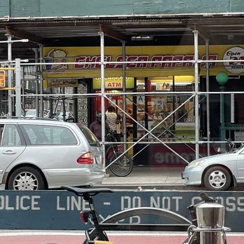 Chelsea Papaya - a bicycle parked in front of a police line don't cross sign - Hot Dogs Near Me - New York, New York