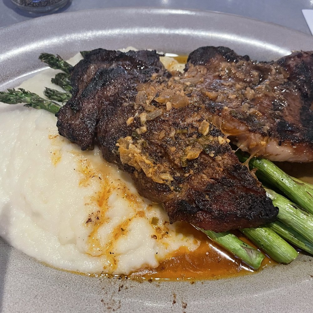 Ribeye steak with cowboy butter, asparagus, and mashed potatoes