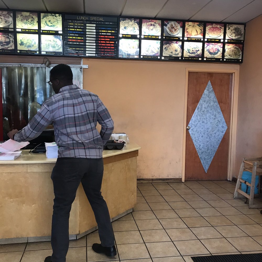 a man standing at a counter in a restaurant a man standing at a counter in a restaurant