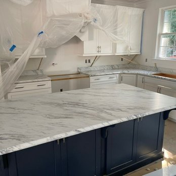 Walsh Tops - The dark island base really makes the marble pattern stand out. You can see the crescent edge detail applied in this photo. - Countertop Installation Near Me - Chesapeake, Virginia Walsh Tops - The dark island base really makes the marble pattern stand out. You can see the crescent edge detail applied in this photo. - Countertop Installation Near Me - Chesapeake, Virginia