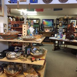Aquarius Books and Gifts - Table displaying abalone shells and several different sage and other herb bundles. The view looking into the "book room".