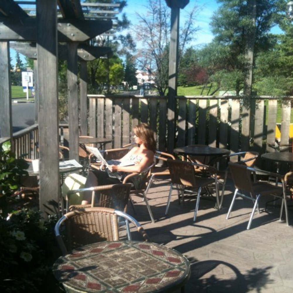 Good Earth Coffeehouse - a woman sitting at a table - Coffee & Tea Near Me - Calgary, Alberta Good Earth Coffeehouse - a woman sitting at a table - Coffee & Tea Near Me - Calgary, Alberta