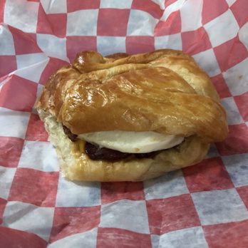 Donut Palace - a croissant sandwich on a checkered paper - Breakfast & Brunch Near Me - Fort Smith, Arkansas
