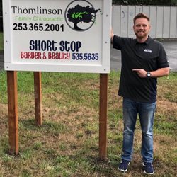 Thomlinson Family Chiropractic - Dr. Zach next to the 1st sign that was made for the practice.