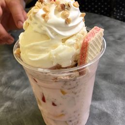 Mixed fruit salad topped w granola and piña colada ice cream and finished of with whip cream and a cherry on top !