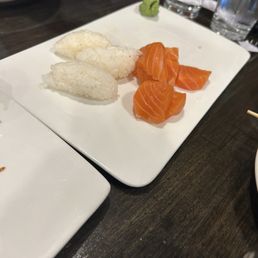 Salmon sushi rice, each overloaded with densely packed rice. sashimi next to the rice showing the quantity Salmon sushi rice, each overloaded with densely packed rice. sashimi next to the rice showing the quantity