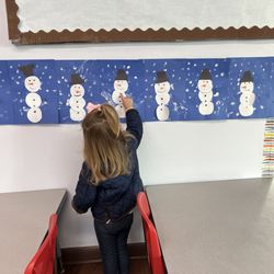 Storybook Ranch Preschool - Pointing at her artwork