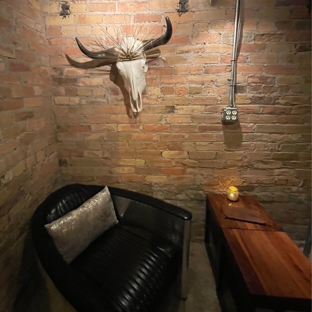 Old Town Cellars - a cow skull mounted on a brick wall - Wine Bars Near Me - Park City, Utah