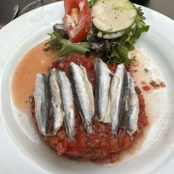 Tomato "carpaccio" topped with anchovies.