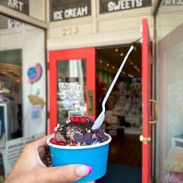 a hand holding a cup of ice cream a hand holding a cup of ice cream