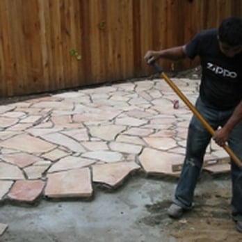 Eclipse - a man using a shovel to level a patio - General Contractors Near Me - Austin, Texas