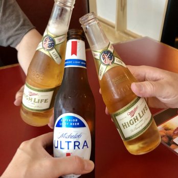 Mt's On 8th - two people clinking beer bottles - Dive Bars Near Me - Saint Cloud, Minnesota
