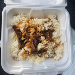 Teriyaki beef - A foam takeout container filled with white rice topped with cooked beef strips in sauce.