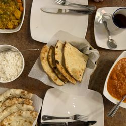 Tandoori Roti, Naan, Basmati Rice, Butter Chicken, and Vegetable Curry.
