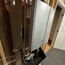 ProFlow Plumbing Services - New Rinnai tankless water heater with custom safety pan to catch water and divert it to the floor drain in case of a leak.