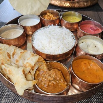 Thali - a variety of indian food on a copper platter - Indian Near Me - Ottawa, Ontario