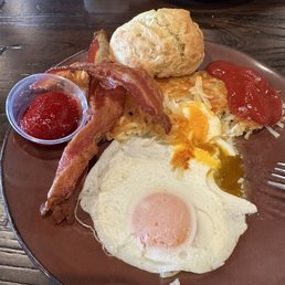 Over easy egg, bacon, hash browns, and a biscuit