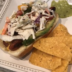 Grilled Veal Dog on a brioche bun, topped with a mango salsa, sliced avocado and creamy slaw.