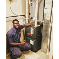 NewTown Energy - Certified HVAC technician next to a newly installed high-efficiency Goodman gas furnace system.