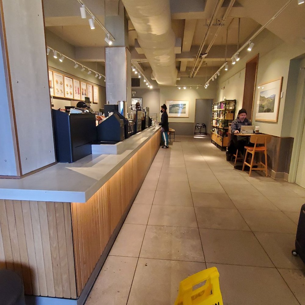 a woman sitting at a table in a coffee shop