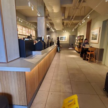 Starbucks - a woman sitting at a table in a coffee shop - Coffee & Tea Near Me - Forest Hills, New York Starbucks - a woman sitting at a table in a coffee shop - Coffee & Tea Near Me - Forest Hills, New York