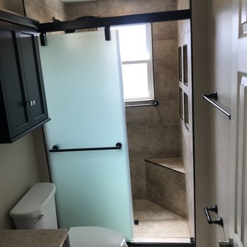 Revival Contracting - a bathroom with a glass shower door - General Contractors Near Me Revival Contracting - a bathroom with a glass shower door - General Contractors Near Me