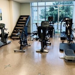 Spero Rehab - South Austin - Cardio area with a rower, bikes, treadmill, elliptical, Jacob's ladder, and upper body bike (UBE)
