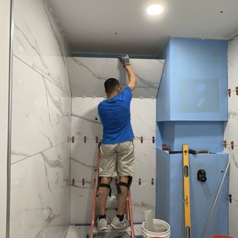 Inspiring Concepts - a man on a ladder in a bathroom - Electricians Near Me Inspiring Concepts - a man on a ladder in a bathroom - Electricians Near Me