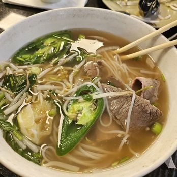 Pho 79 - a bowl of beef and vegetable soup with chopsticks - Vietnamese Near Me - Miami, Florida Pho 79 - a bowl of beef and vegetable soup with chopsticks - Vietnamese Near Me - Miami, Florida