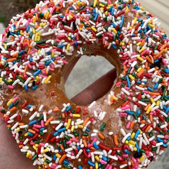 Country Donuts - a hand holding a chocolate donut with sprinkles - Donuts Near Me - Boise, Idaho Country Donuts - a hand holding a chocolate donut with sprinkles - Donuts Near Me - Boise, Idaho