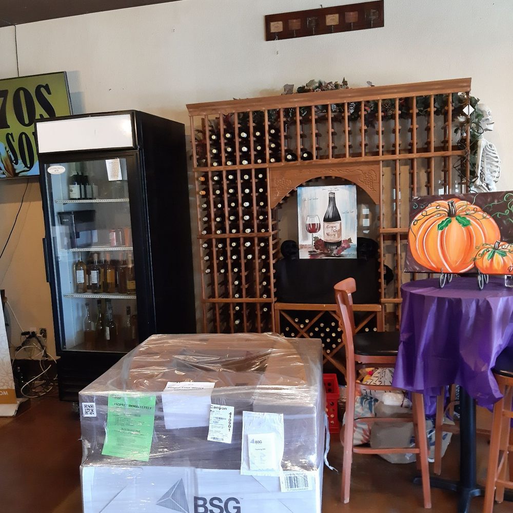 Canyon Crest Winery - a wine cellar with a table and chairs - Wine Bars Near Me - Riverside, California