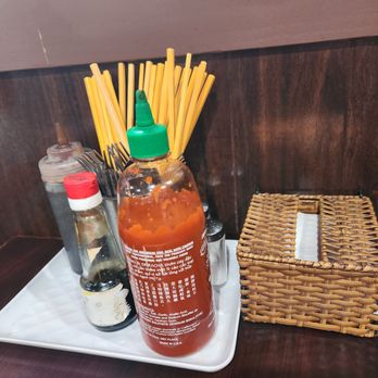 Pho Cali - a bottle of hot sauce and a wicker basket - Vietnamese Near Me - Philadelphia, Pennsylvania