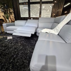 Indulge in refined comfort with this light-gray Italian leather sectional, complete with two recliners and adjustable headrests for a custom
