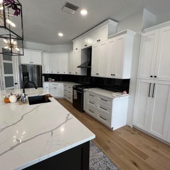Rose Family Services - a kitchen with white cabinets and marble countertops - Flooring Near Me Rose Family Services - a kitchen with white cabinets and marble countertops - Flooring Near Me