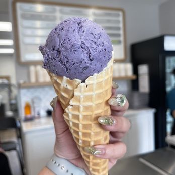 Annie Rue Ice Cream - a hand holding a cone of purple ice cream - Ice Cream & Frozen Yogurt Near Me - Edmonton, Alberta Annie Rue Ice Cream - a hand holding a cone of purple ice cream - Ice Cream & Frozen Yogurt Near Me - Edmonton, Alberta