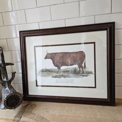 Yard Bull Meats - A framed artwork of a cow hangs from one of the brick walls painted white.
