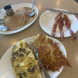 Omlett, bacon, pancakes and hash browns.