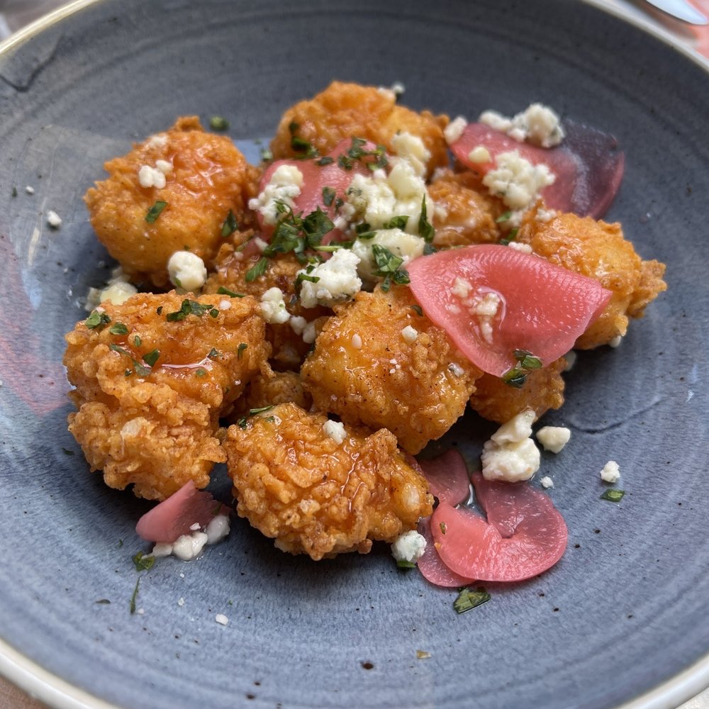 Cadre Restaurant - Chèvre cheese curds with a pickled radish, blues cheese crumbles and a sweet drizzle. - French Near Me - Madison, Wisconsin Cadre Restaurant - Chèvre cheese curds with a pickled radish, blues cheese crumbles and a sweet drizzle. - French Near Me - Madison, Wisconsin
