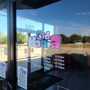KidMania - Kid Mania's business hours are listed on the glass door, with the logo visible, indicating it is a family entertainment center. - Arcades Near Me - Plano, Texas