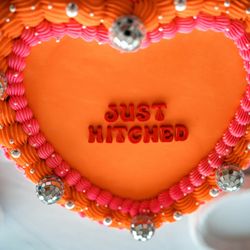 Little Sugar Crumb Sweets - Orange and pink vintage-style wedding cake that says Just Hitched with disco balls for decoration