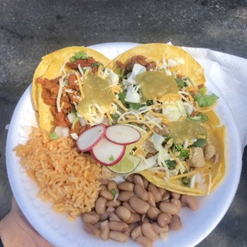 Homies Tacos - a person holding a plate of food - Food Trucks Near Me