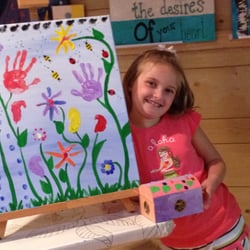 All Things Art Studio - Birthday girl with her art project and the birthday canvas mural she and her friends created for her to take home.