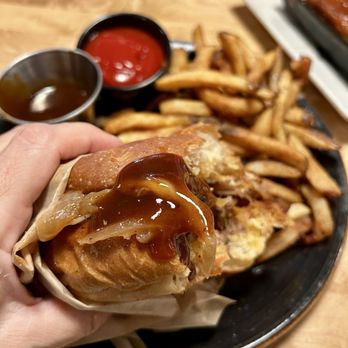 Sharps Roasthouse - Bacon barbecue brisket sandwich with coleslaw on the side and a bit extra barbecue sauce on this bite! - American Near Me - SeaTac, Washington