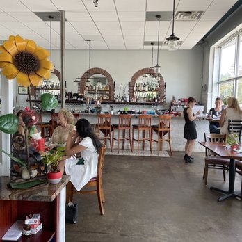 Cecilia's Kitchen - a woman sitting at a table in a restaurant - Latin American Near Me - Asheville, North Carolina