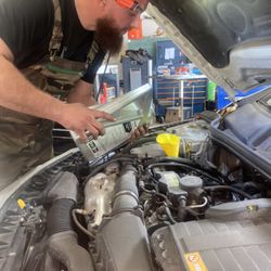 Driven Performance Auto Group - Tech performing oil change on customers car.