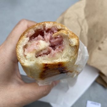 Cachitos - a hand holding a half eaten sandwich - Cafes Near Me - Montreal, Quebec