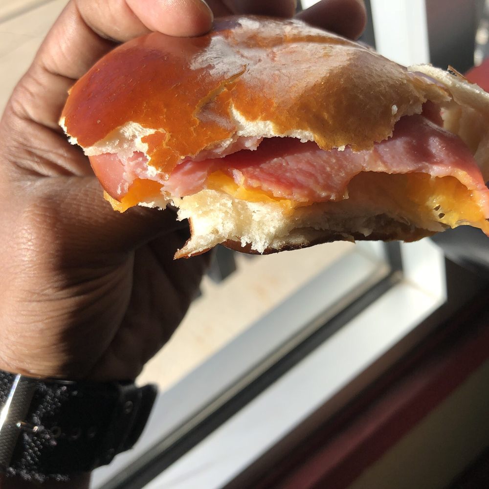 Pinckney Bakery - a hand holding a half eaten sandwich - Bakeries Near Me - Pinckney, Michigan Pinckney Bakery - a hand holding a half eaten sandwich - Bakeries Near Me - Pinckney, Michigan