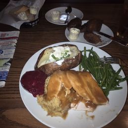 Roast turkey dinner with baked potato and green beans and side order of carrot raisin Madeline's (muffin tops), delicious